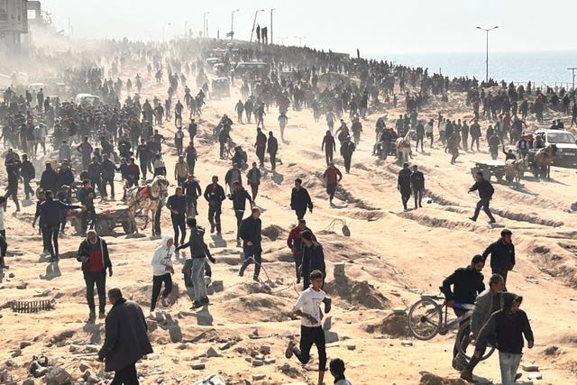 Palestinians wait for humanitarian aid on a beachfront in Gaza City 