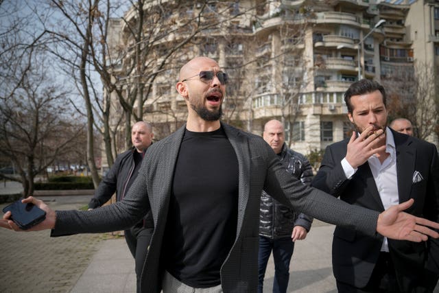 Andrew Tate, center, gestures as he arrives with his brother Tristan at the Bucharest Tribunal in February