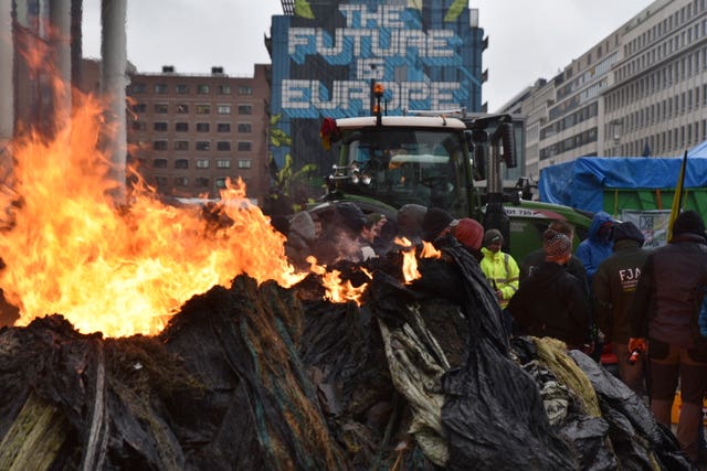 Protesters light fires during a farmers' demonstration in the European Quarter outside a meeting of EU agriculture ministers in Brussels in February