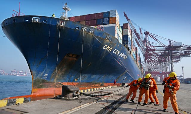 Workers dock a container vessel at a port in China 