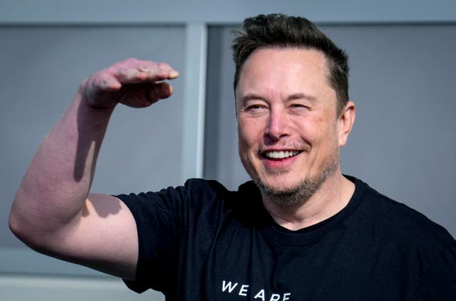 Elon Musk waves and smiles