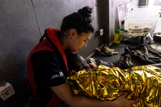 The rescue personnel of the SOS Mediteranee’s humanitarian ship Ocean Viking attend migrants rescued from a deflating rubber dinghy in the Central Mediterranean Sea 