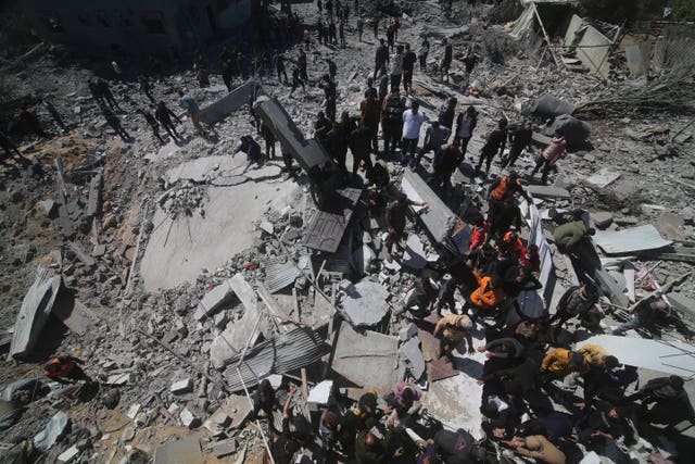 Palestinians look at a residential building destroyed in an Israeli strike in Rafah, Gaza Strip 