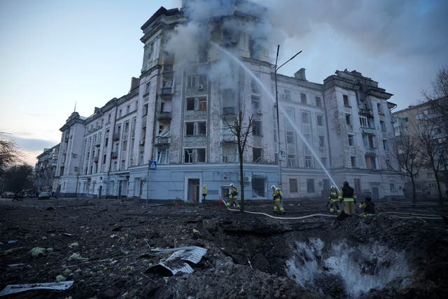 Firefighters work near the crater at the site after Russian attacks in Kyiv, Ukraine 