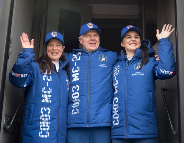 Nasa astronaut Tracy Dyson, left, Roscosmos cosmonaut Oleg Novitskiy, and Belarus spaceflight participant Marina Vasilevskaya, right, wave as they depart the Cosmonaut Hotel to suit-up for their Soyuz launch to the International Space Station in Baikonur, Kazakhstan
