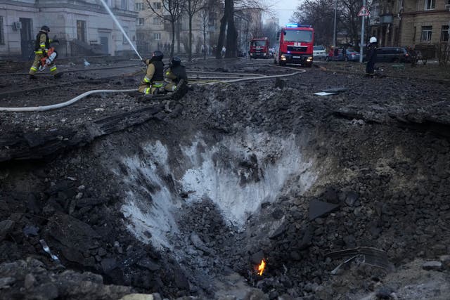 Firefighters work near a crater after a Russian attack in Kyiv, Ukraine 