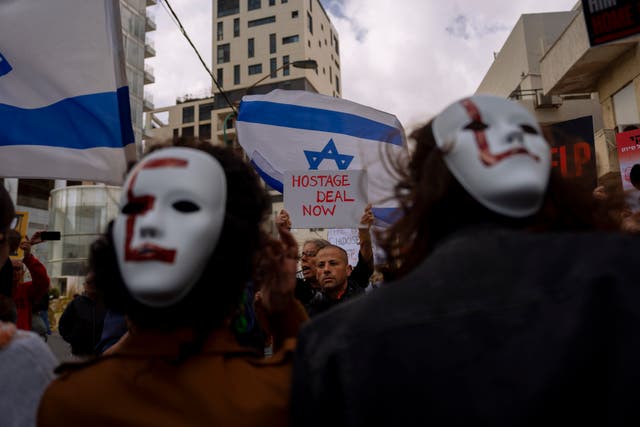 Families and supporters of Israeli hostages held by Hamas in Gaza wave signs and the Israeli and US flags during a protest calling for their return, outside a meeting between US secretary of state Antony Blinken and families of hostages, in Tel Aviv, Israel