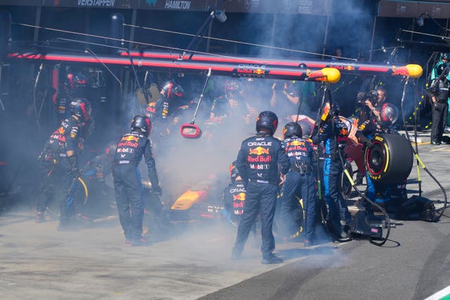 Mechanics work to extinguish a fire in Max Verstappen's Red Bull car 