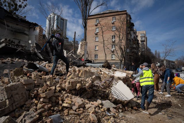 Volunteers and students of the Kyiv State Arts Academy clear the rubble after it was hit during a Russian missile attack