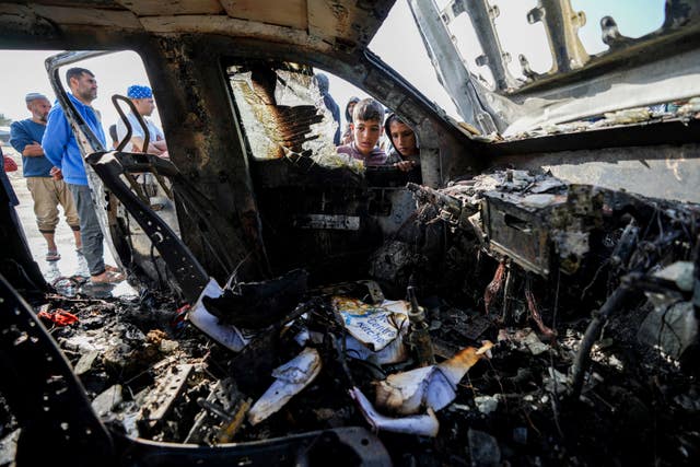 People inspect the site where World Central Kitchen workers were killed in Deir al-Balah, Gaza Strip