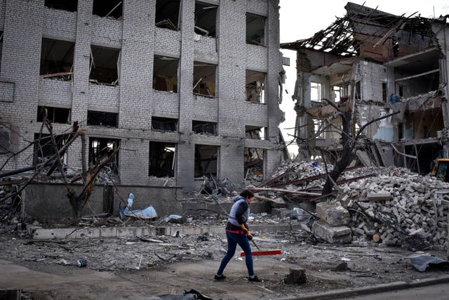 A local resident clears debris near a building damaged in the Russian air raid in the town of Orikhiv, Zaporizhzhia region, Ukraine