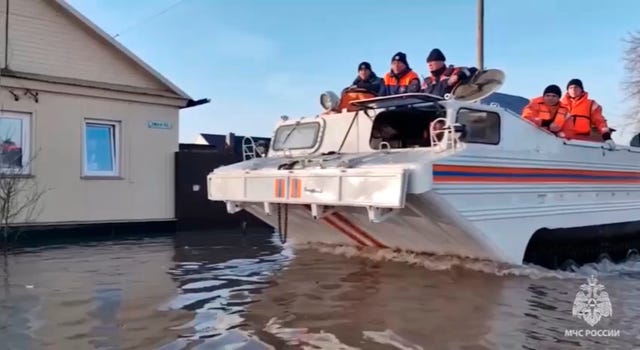 Emergency workers aboard an amphibious vehicle look to evacuate local residents after a part of a dam burst causing flooding in Orsk, Russia
