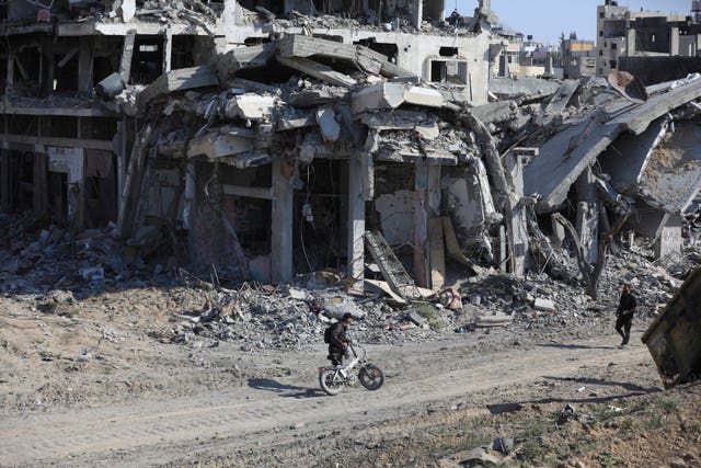 Palestinians walk through the destruction left by the Israeli air and ground offensive after they withdrew from Khan Younis, southern Gaza Strip 
