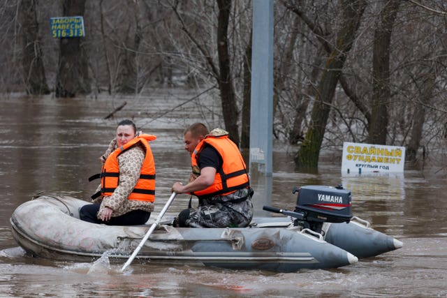 Rescuers use a boat in a flooded area of Orenburg, Russia