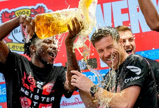 Xabi Alonso, centre, is doused with beer as Bayer Leverkusen celebrate the Bundesliga title after beating Werder Bremen