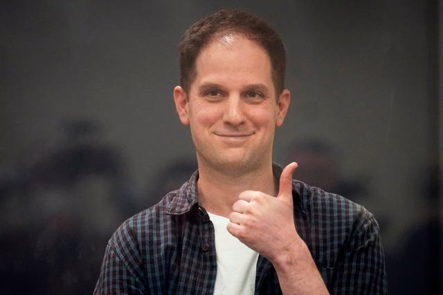 Wall Street Journal reporter Evan Gershkovich gives a thumbs-up and smiles as he stands in a glass cage in a courtroom at the First Appeals Court of General Jurisdiction in Moscow, Russia, on April 23 2024 