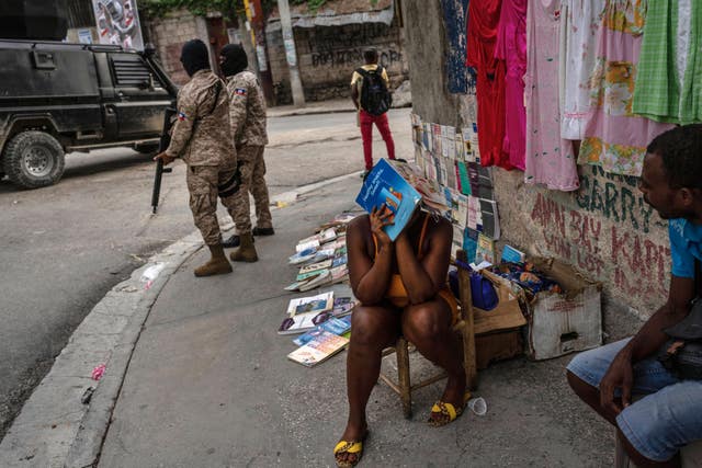 Police officers patrol next to a street vendor in Port-au-Prince