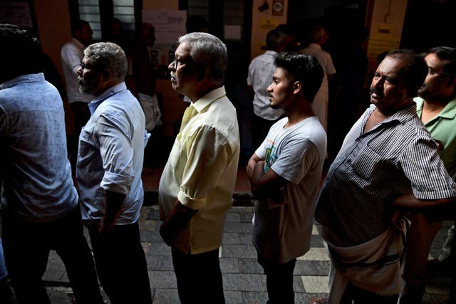 People queue up to vote during the second round of voting in the six-week long national election outside a polling booth in Kochi