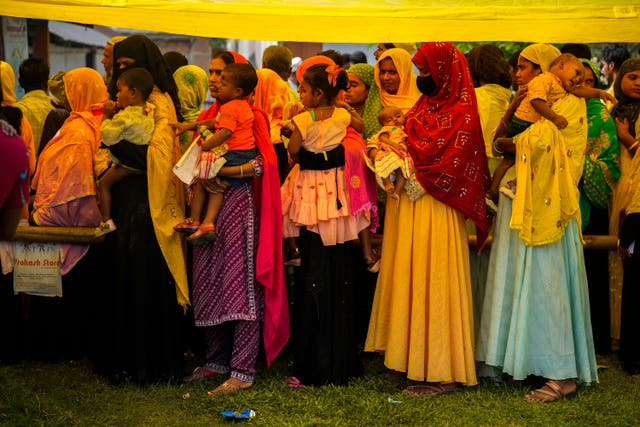 Women queue up to cast their votes in a polling station on the bank of the Brahmaputra river 