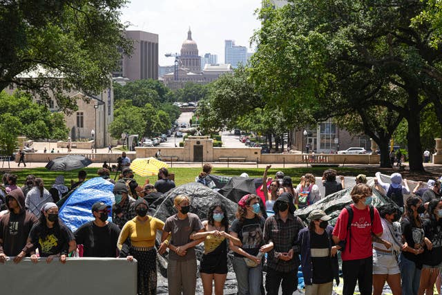 Protesters link arms at an encampment at the University of Texas at Austin