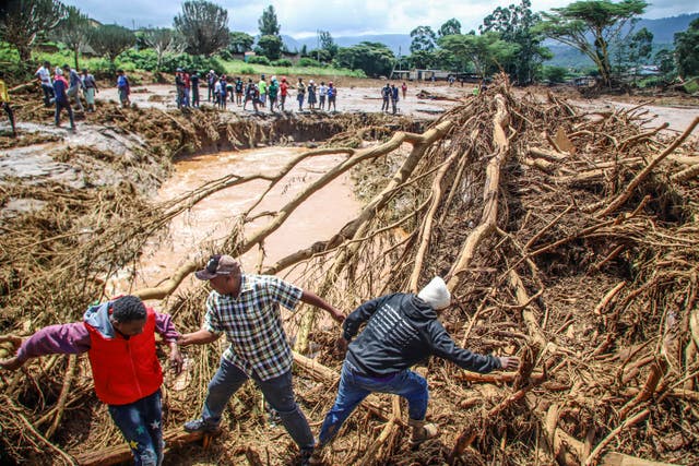 People try to clear the area after a dam burst in Kenya