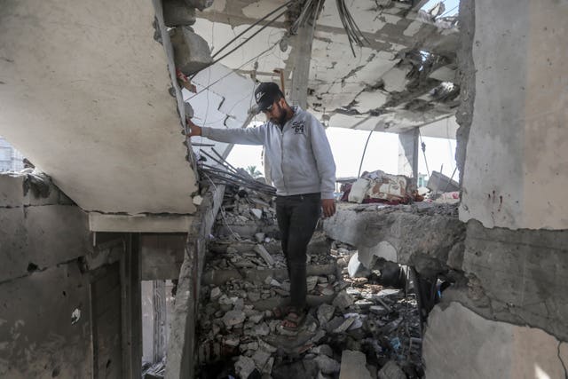 A Palestinian stands in the ruins of the Chahine family home after an overnight Israeli strike that killed at least two adults and five boys and girls under the age of 16 in Rafah, southern Gaza Strip