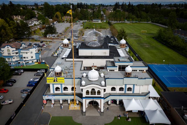 In this photograph taken with a drone, people sit on the front lawn of the Guru Nanak Sikh Gurdwara, in Surrey, British Columbia 