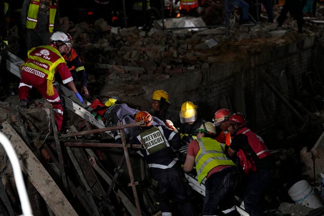 A survivor is brought to the surface at the scene of the building collapse 
