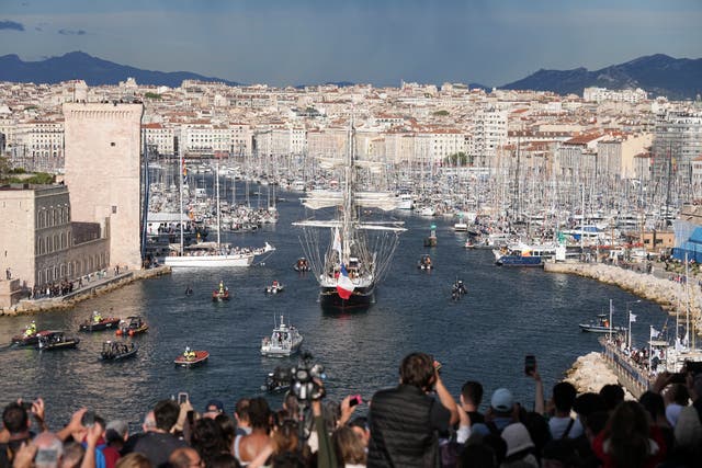 Crowds watch as the Belem, the three-masted sailing ship bringing the Olympic flame from Greece, enters the Old Port in Marseille, southern France 