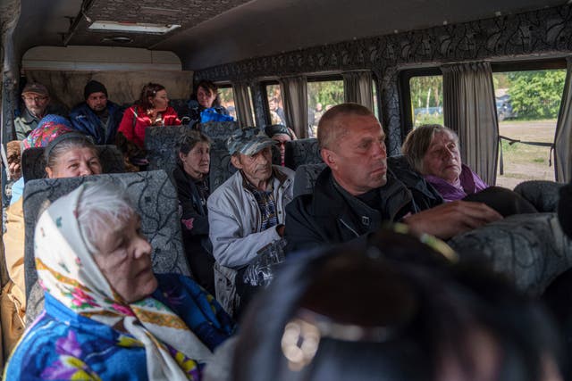 People sit in a bus after evacuation from Vovchansk, Ukraine 