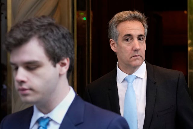 Michael Cohen, right, leaves his apartment building in New York