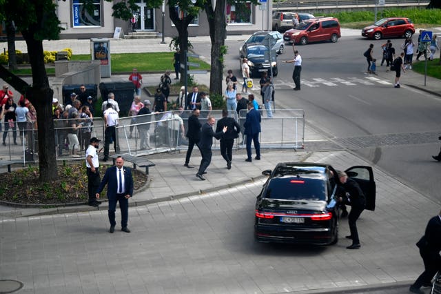 Bodyguards take Slovak Prime Minister Robert Fico in a car from the scene after he was shot and injured following the cabinet’s away-from-home session in the town of Handlova, Slovakia 