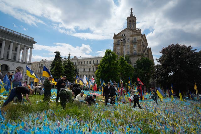 Volunteers put in order the site of an improvised memorial to fallen soldiers on Independence Square in Kyiv, Ukraine 