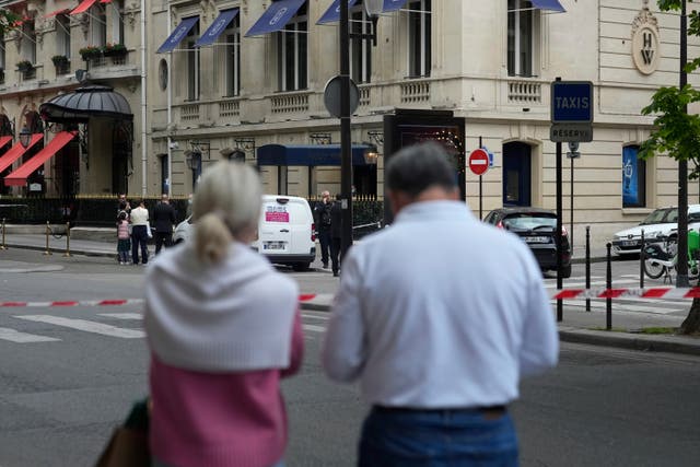 Onlookers watch the entrance of the Harry Winston jewellery after a robbery in Paris