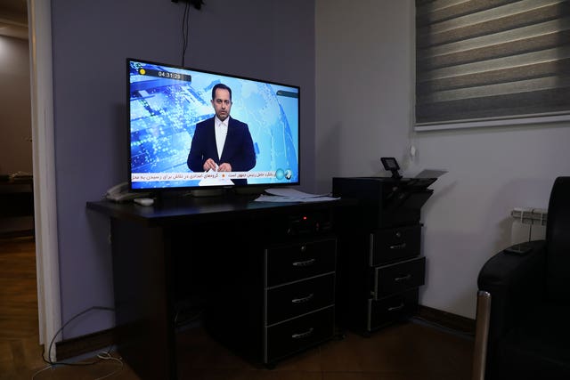 An Iranian state TV newsreader reads news on an incident of a helicopter carrying Iranian President Ebrahim Raisi in north-western Iran