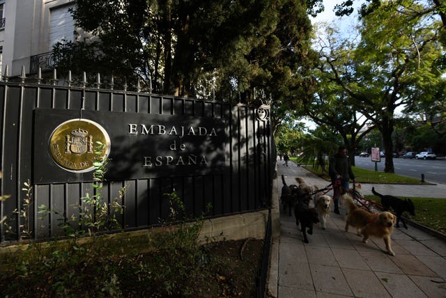 Un hombre pasea a sus perros frente a la Embajada de España en el barrio de Palermo de Buenos Aires, Argentina.