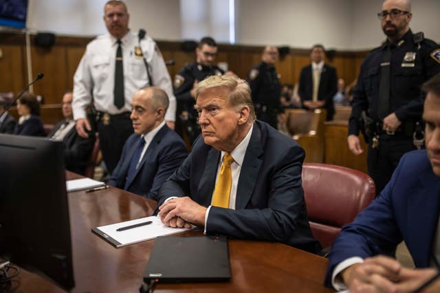 Donald Trump sits between his lawyers Emil Bove, left, and Todd Blanche, right, before the start of the day’s proceedings in the Manhattan Criminal Court in New York