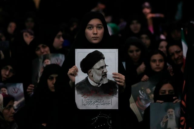 A woman holds a poster of the late Iranian President Ebrahim Raisi at mam Khomeini Grand Mosque in Tehran
