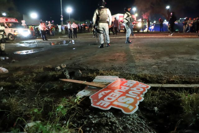 Electoral signs lay on the ground as security forces secure the area after the incident 
