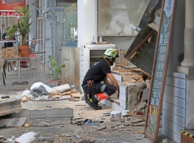 A firefighter looks at part of a collapsed building in Palma de Majorca, Spain 
