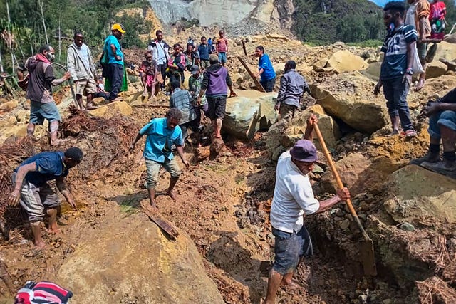 Villagers search through a landslide in Yambali, in the Highlands of Papua New Guinea