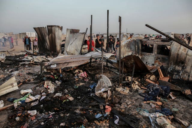 Palestinians look at the destruction after an Israeli strike where displaced people were staying in Rafah, Gaza Strip