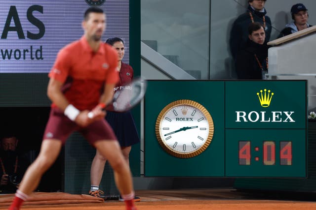 Novak Djokovic waits to return a serve in front of a scoreboard which shows the time at 2.42am