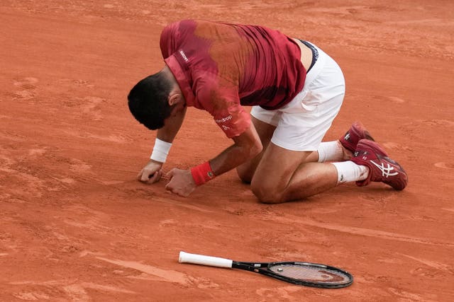 Novak Djokovic on his knees after slipping at Roland Garros 