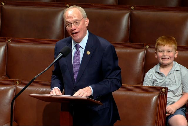 John Rose speaking on the floor of the House of Representatives as his son Guy makes a face