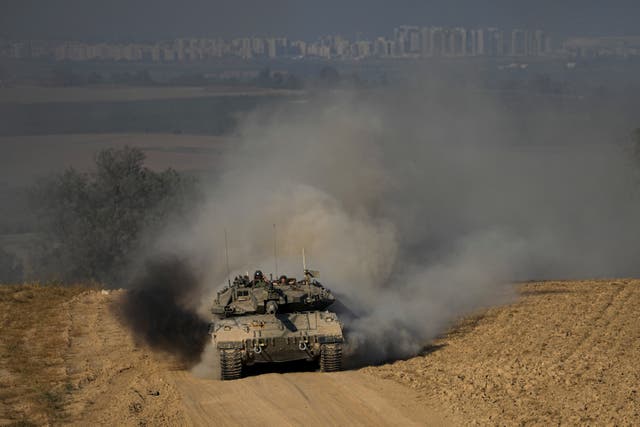 Israeli soldiers drive a tank near the Israeli-Gaza border