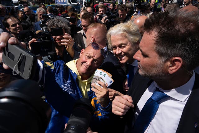 Geert Wilders, centre right, smiles as he poses while surrounded by voters