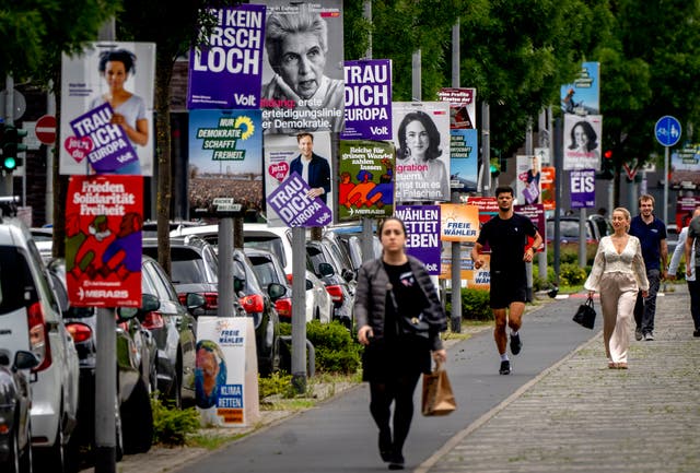 Lampposts decorate with campaign posters along a street