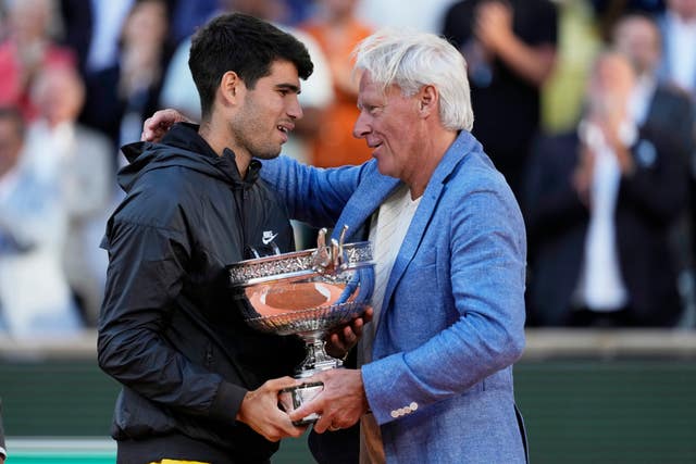 Carlos Alcaraz receives the trophy from Bjorn Borg 