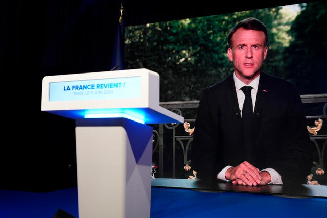 French President Emmanuel Macron appears on a television screen at the French far-right National Rally party election night headquarters in Paris 